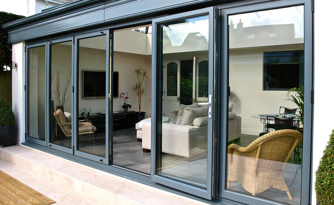 Extension with grey aluminium bifold doors - Plan-it Windows